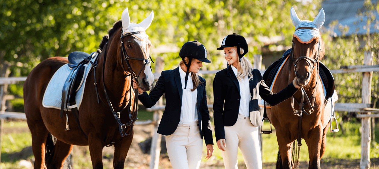 Zwei junge Reiterinnen mit ihren Pferden